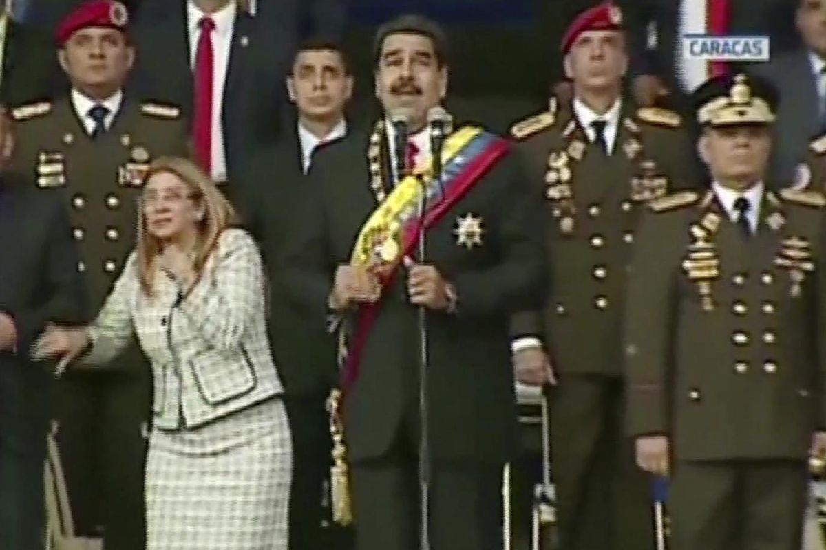 In this still from a video provided by Venezolana de Television, Presiden Nicolas Maduro, center, delivers his speech as his wife Cilia Flores winces and looks up after being startled by and explosion, in Caracas, Venezuela, on Saturday, Aug. 4, 2018. (AP)