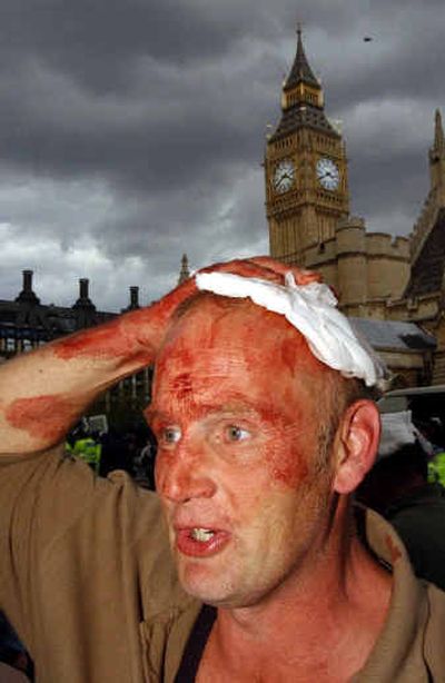 
A man holds a bandage to his bloodied head after protesters and police clashed outside the houses of Parliament Wednesday in London. 
 (Associated Press / The Spokesman-Review)