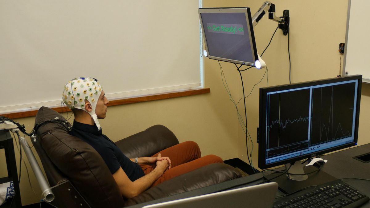 University of Washington graduate student Jose Ceballos wears an electroencephalography cap that records brain activity and sends a response to a second participant over the Internet. (University of Washington / University of Washington)