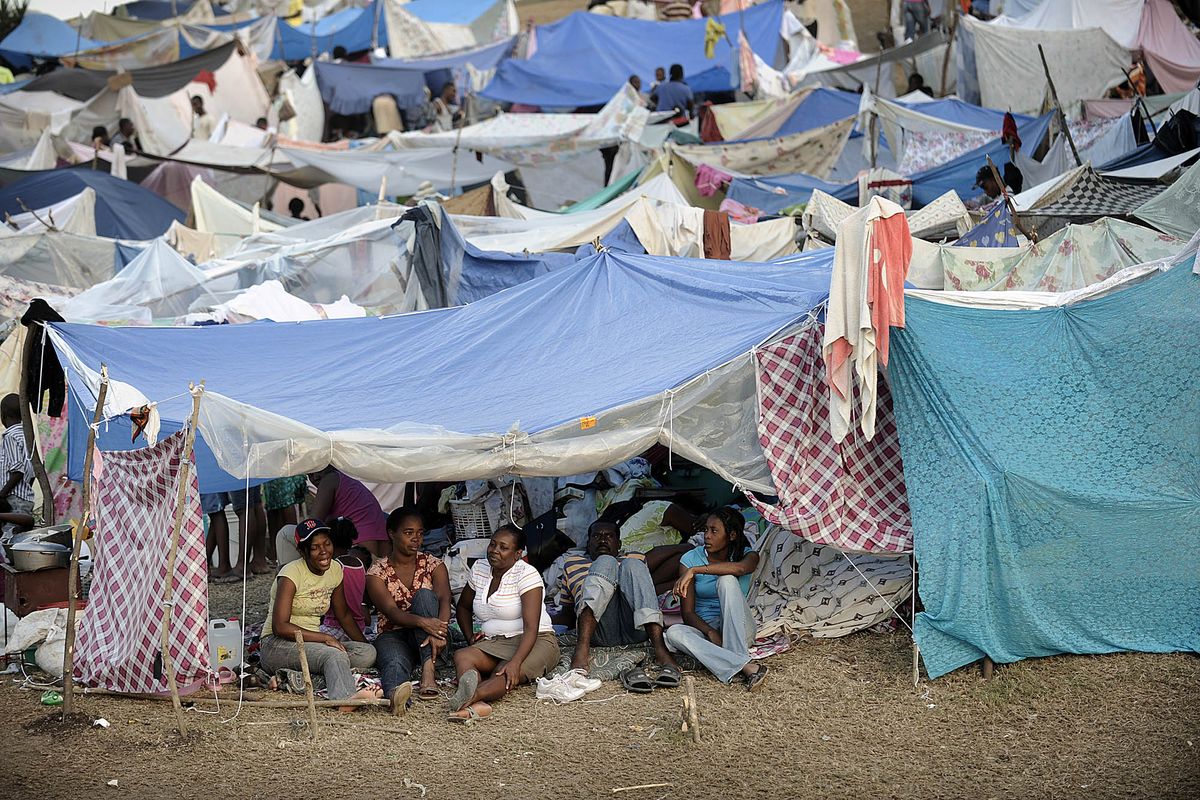 A family relaxes in their tent in Port-au-Prince, Haiti, on Monday. The U.S. Army is distributing food and water at the tent city. South Florida Sun-Sentinel (Michael Laughlin South Florida Sun-Sentinel)