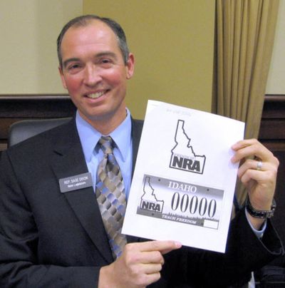 State Rep. Sage Dixon, R-Sandpoint, shown here holding up a mock-up of a specialty plate bill in sponsored last year, is the lead sponsor of the Bible-in-schools bill that won a House vote today. (Betsy Russell, Eye on Boise)