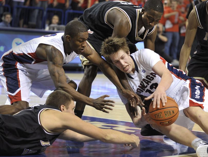 Gonzaga's Kelly Olynyk (13) tries to hold possession of a loose ball, as (left, bottom to top) IUPUI's Mitchell Patton, Gonzaga's Demetri Goodson and IUPUI's Alex Young make a play for the ball in the second half Sunday, Nov. 14, 2010 in the McCarthey Athletic Center. (Colin Mulvany / The Spokesman-Review)