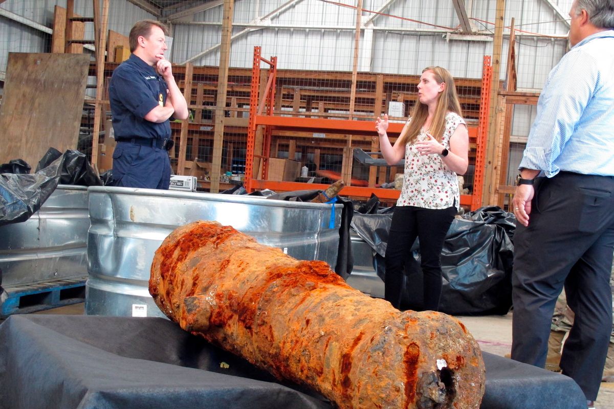 Commodore Philip Nash, left, of the British Royal Navy, gets a briefing from U.S. Army Corps of Engineers archaeologist Andrea Farmer on Thursday in Savannah, Ga. Nineteen cannons were recovered from the Savannah River believed to be from the American Revolution era.  (Russ Bynum)