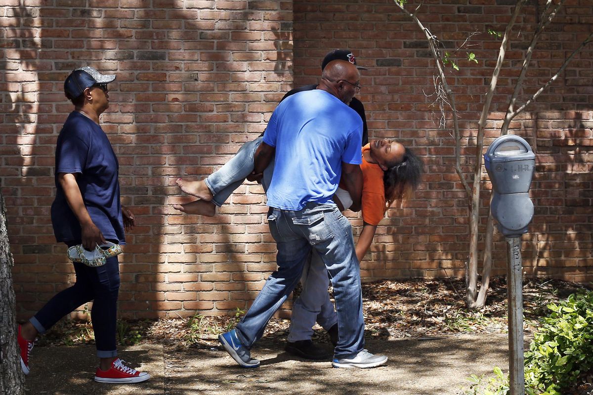 Family members carry a grief-stricken Ebony Archie, mother of Kingston Frazier, after learning the young boy was found dead after being kidnapped during the theft of his mother