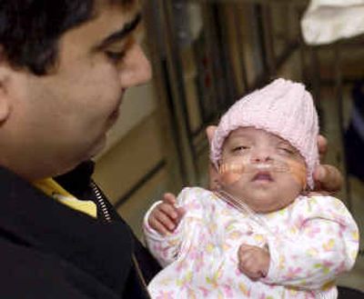 
In a photo provided by the Loyola University Health System, Mohammed Abdul Rahman holds his daughter on Tuesday, as they prepare to leave the Loyola University Medical Center. 
 (Associated Press / The Spokesman-Review)