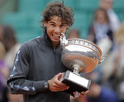 Rafael Nadal of Spain bites the trophy after winning the men’s French Open final Monday. (Associated Press)