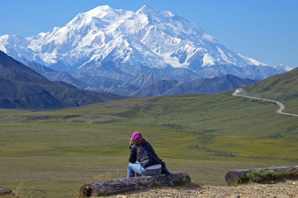 A woman gazes at Denali, formerly Mount McKinley, from one of the few roads in the park. (Associated Press)