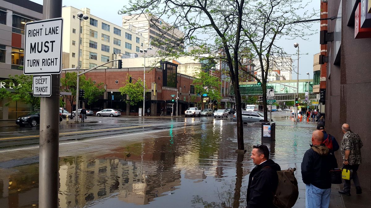 The intersection of Post Street and Riverside Avenue in downtown Spokane is submerged in several inches of water after a sudden downpour Thursday afternoon. (Chad Sokol / The Spokesman-Review)