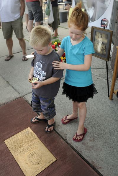In the line of duty: August Grainger, 5, and his sister Autumn, 7, look down at the memorial plaque they helped unveil Tuesday, at the corner of Garland Avenue and Howard Street in Spokane. The two are the great-great-grandchildren of Thomas Sparrow, a Spokane firefighter who died at that location while fighting a house fire in 1939. Several descendants of Sparrow were on hand for the unveiling, the third in a series of 17 plaques laid to honor firefighters who died in the line of duty. Find a picture gallery at www.spokesman.com (Jesse Tinsley)