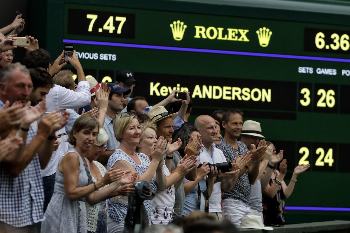 Spectators applaud as the scoreboard displays the final score in the men’s singles semifinals match in which John Isner of the United States was defeated by South Africa’s Kevin Anderson, at the Wimbledon Tennis Championships, in London, Friday July 13, 2018. (Kirsty Wigglesworth / Associated Press)