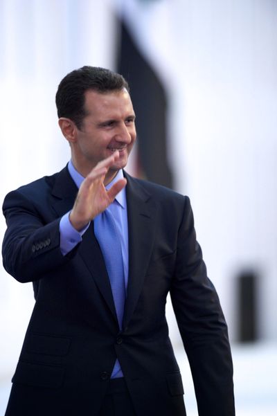 Syria's President Bashar Assad waves to his supporters upon his arrival to the presidential palace. (Associated Press)