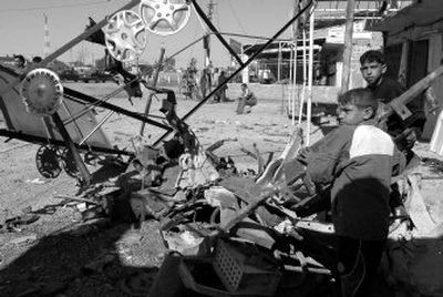 
Children stand amid debris  after a truck carrying chlorine gas  was destroyed by a bomb in Taji, Iraq, on Tuesday. Nine people died, and more than 150  were hospitalized. 
 (Associated Press / The Spokesman-Review)