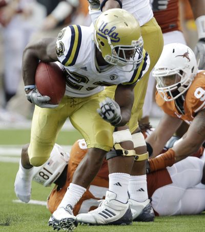 UCLA's Jonathan Franklin runs around Texas defenders during the first quarter. (Associated Press)