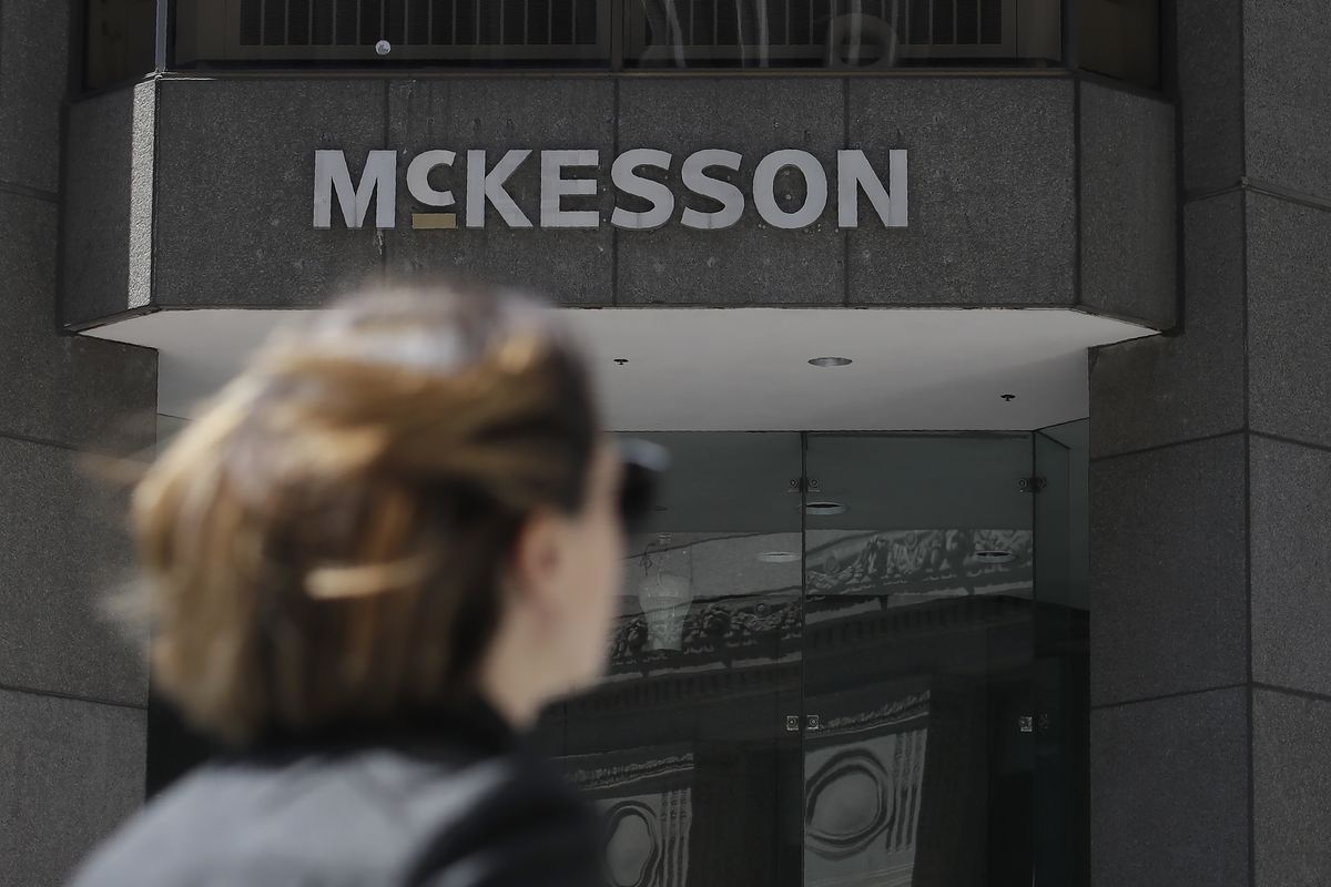 In this July 17, 2019 photo, a pedestrian passes a McKesson sign on an office building in San Francisco. Four companies say they