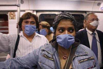 Subway commuters wear surgical masks as a precaution against swine flu infection in Mexico City on Friday.  (Associated Press / The Spokesman-Review)