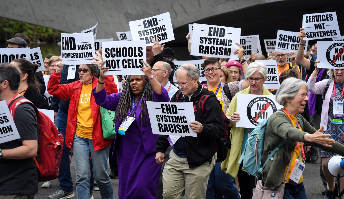 A crowd marches from the Spokane Convention Center through Riverfront Park to a rally opposing jail expansion on Thursday, June 20, 2019. (Dan Pelle / The Spokesman-Review)