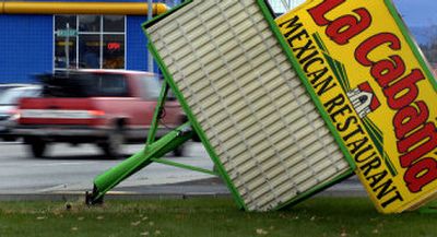 
The La Cabana Mexican Restaurant's sign was blown to the ground in Post Falls by the storm's high winds. 
 (Kathy Plonka / The Spokesman-Review)