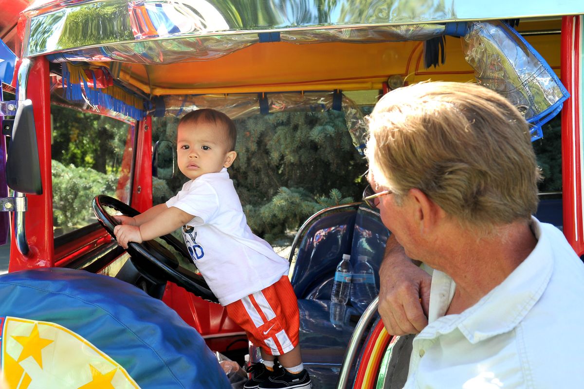 Sean Martin, 1, poses for a picture in a jeepney, a mass transit vehicle from the Philippines, on Saturday, Aug. 20, 2011 at Unity in the Community at Riverfront Park. The boy is half Filipino. At right is Randy Palmer of the Filipino American Association of the Inland Empire, which brought the vehicle. For the event, the park was packed with booths representing foreign countries and community groups, and there were live performances and food booths in the clocktower meadow. (Jesse Tinsley / The Spokesman-Review)