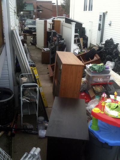 This Nov. 1, 2012, photo taken from Facebook shows a broken fence and a number of items belonging to Associated Press sports writer Dennis Waszak Jr., and his family that were cleaned out of the basement after their 