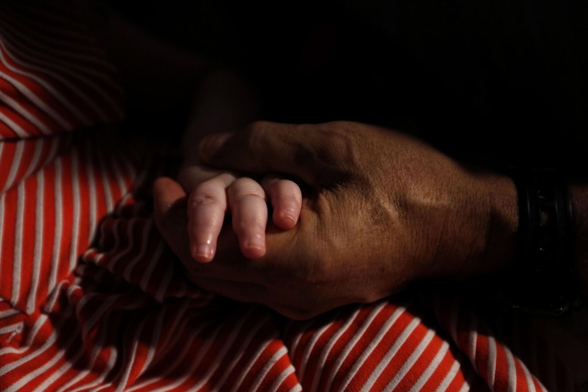 Mohamed Bzeek holds the hand of his 6-year-old foster daughter, who was born with a rare brain malformation. (Genaro Molina / TNS)