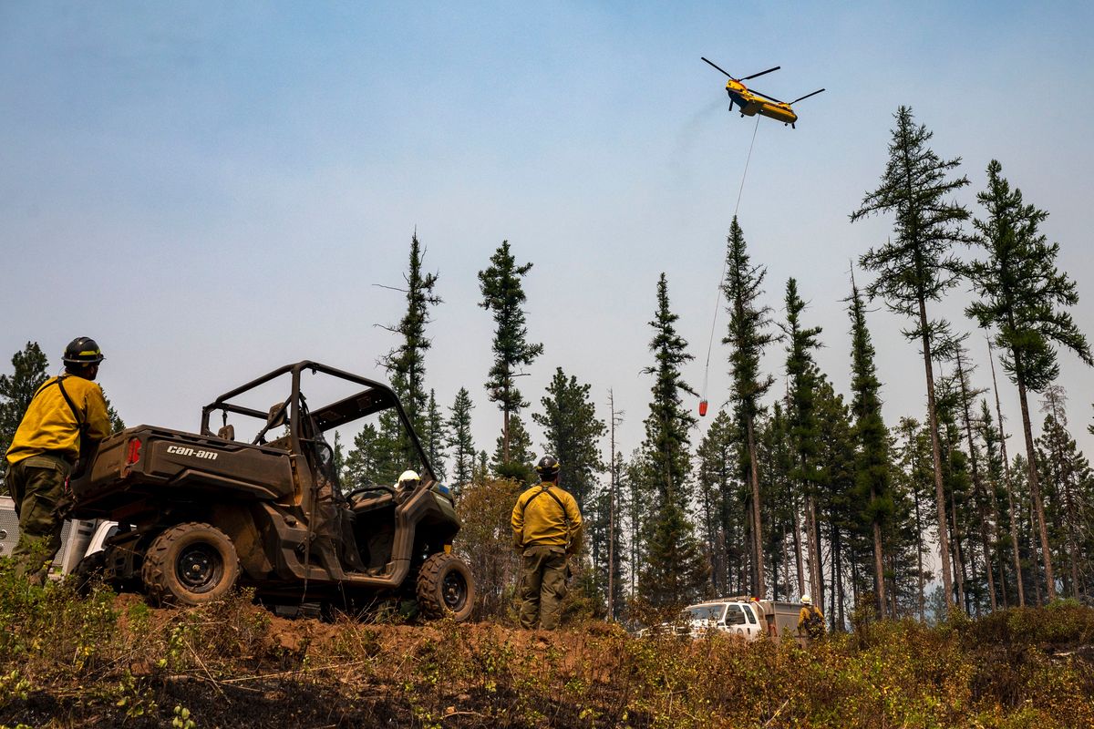 A crew of wildland firefighters watches as a helicopter drops water on hot spots along Captain John Ridge in July 2021 at the Snake River Complex Fire south of Lewiston. The fire had burned over 100,000 acres in north-central Idaho.  (Pete Caster/Lewiston Tribune)