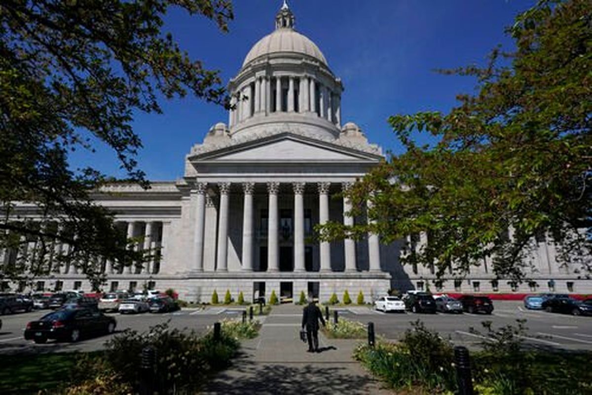 A person walks near the Legislative Building last spring in Olympia. Legislators say they plan to work on fixing the long-term care tax that goes into effect Jan. 1.  (Ted S. Warren)