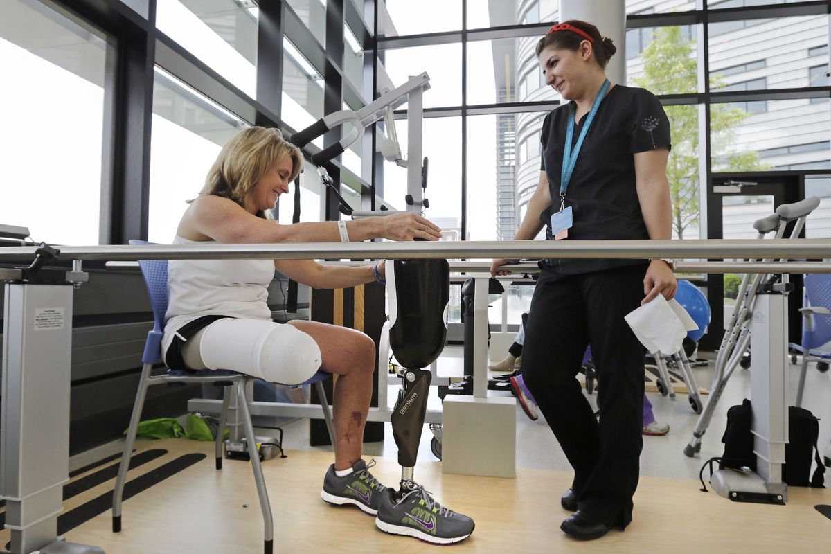Roseann Sdoia prepares to fit her prosthetic leg as she talks with physical therapist Dara Casparian at the Spaulding Rehabilitation Hospital in Boston. (Associated Press)