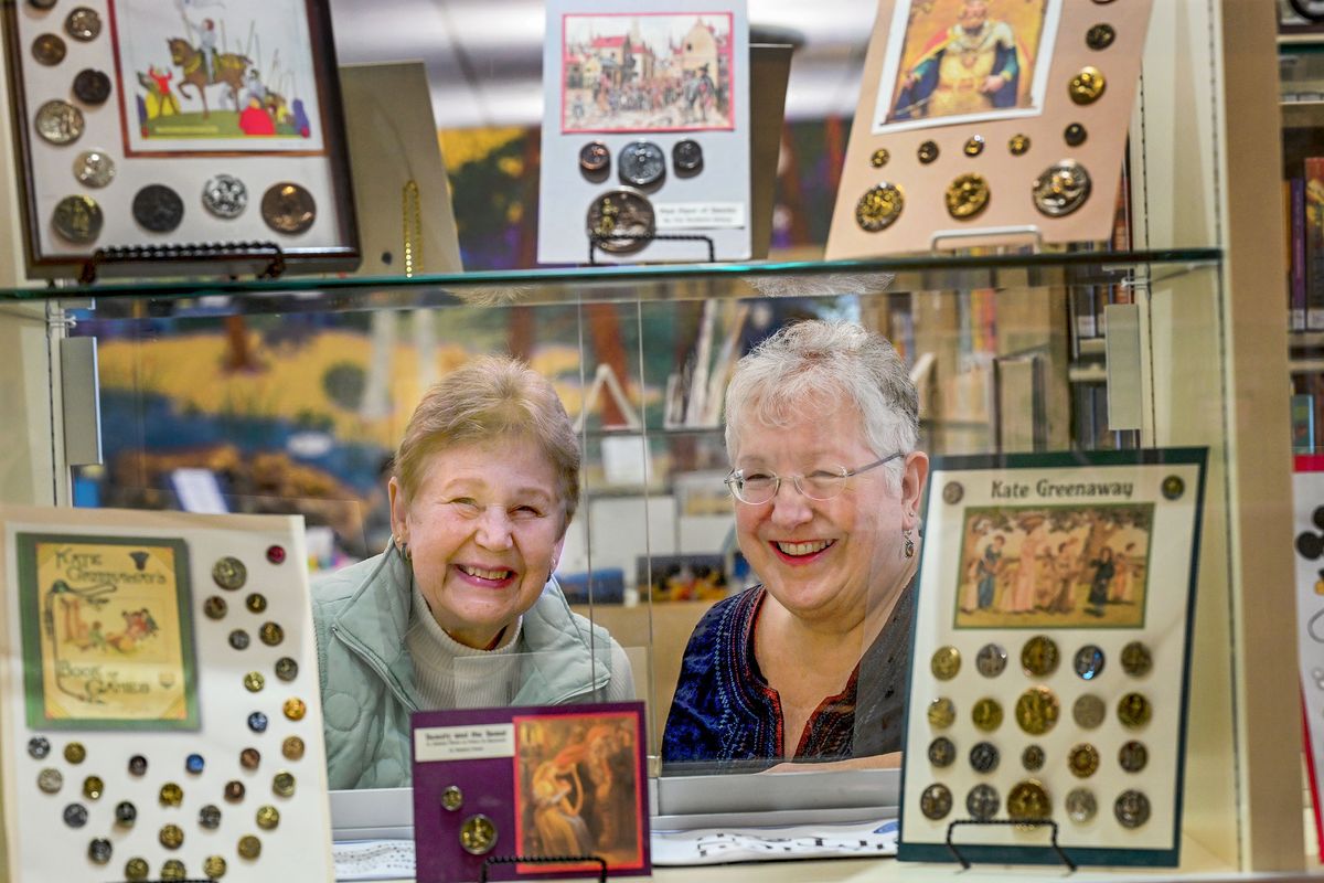 Historical Button Club members Kristy Eversole, left, and Simone Kincaid are photographed March 5 near the display at the Coeur d’Alene Library.  (Kathy Plonka / The Spokesman-Review)