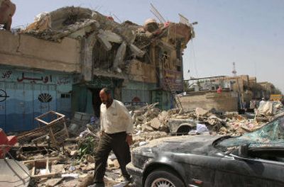
An Iraqi man walks past wreckage from a massive bomb attack early Monday in Baghdad, Iraq. 
 (Associated Press / The Spokesman-Review)