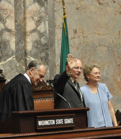 Mike Padden, with his wife Laura, waves to family and friends after being sworn in by Supreme Court Justice Jim Johnson (Jim Camden)