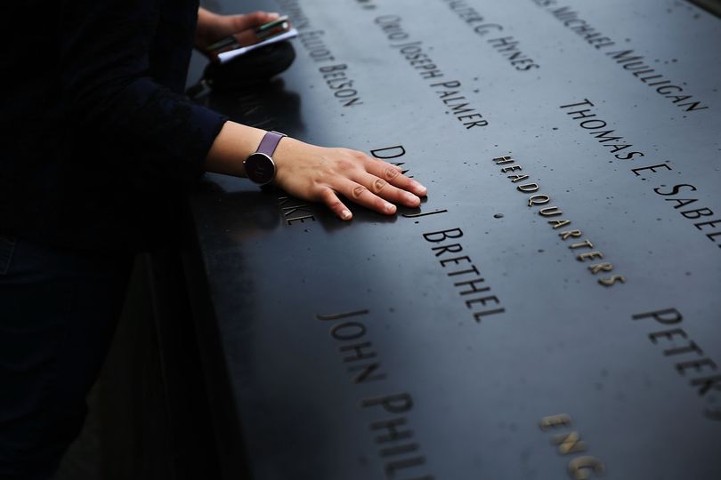 A woman places a hand on the names engraved along the South reflecting pool at the Ground Zero memorial site during the dedication ceremony of the National September 11 Memorial Museum in New York on Thursday, May 15, 2014. (Spencer Platt / Pool Getty Images)