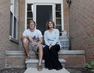 Linda Rogers sits with her son Mike MacLean, 18, outside her home in Northville, Mich. Rogers can just keep up with her $2,200 monthly mortgage payment and the rest of her bills, but she has no wiggle room in her budget.  (Associated Press)