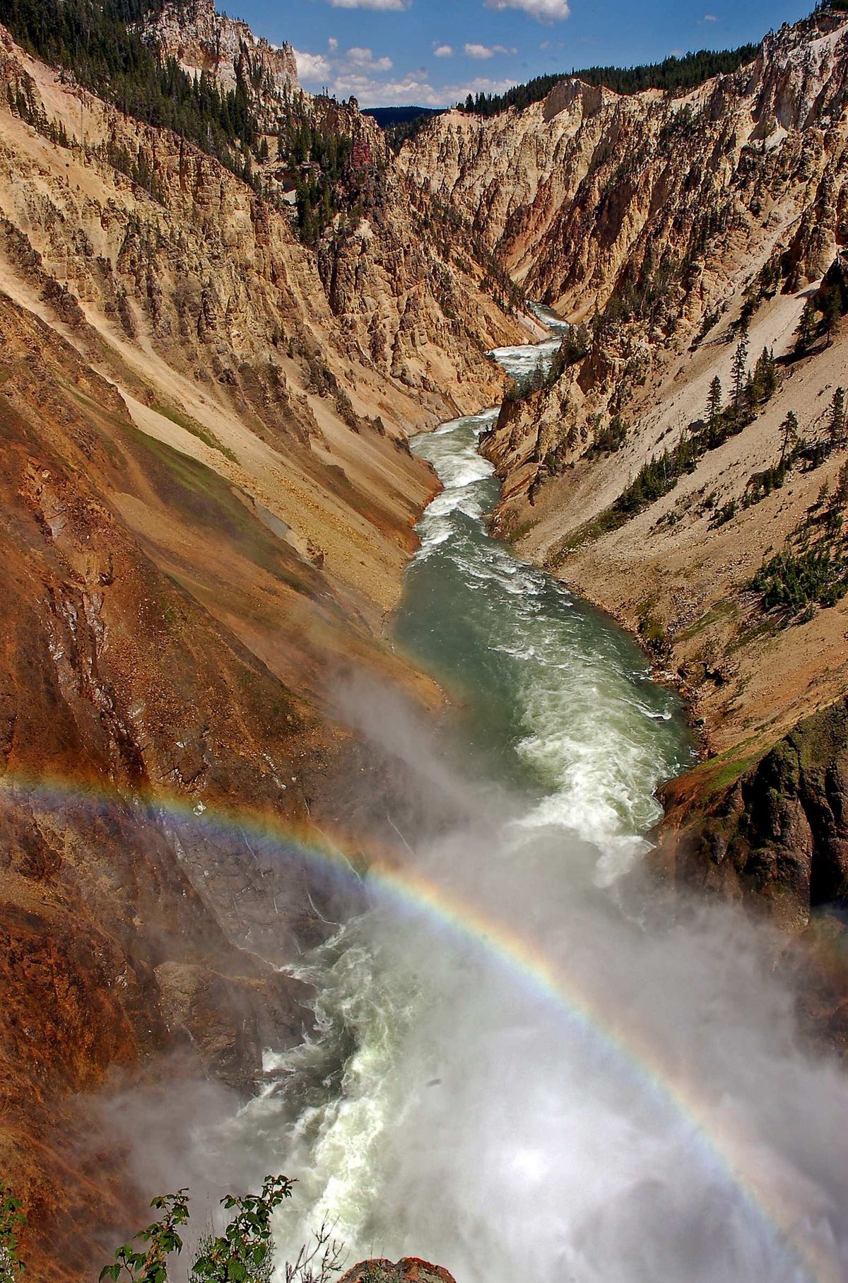 A rainbow arcs over the canyon at the Lower Falls of the Yellowstone River in Yellowstone National Park. 