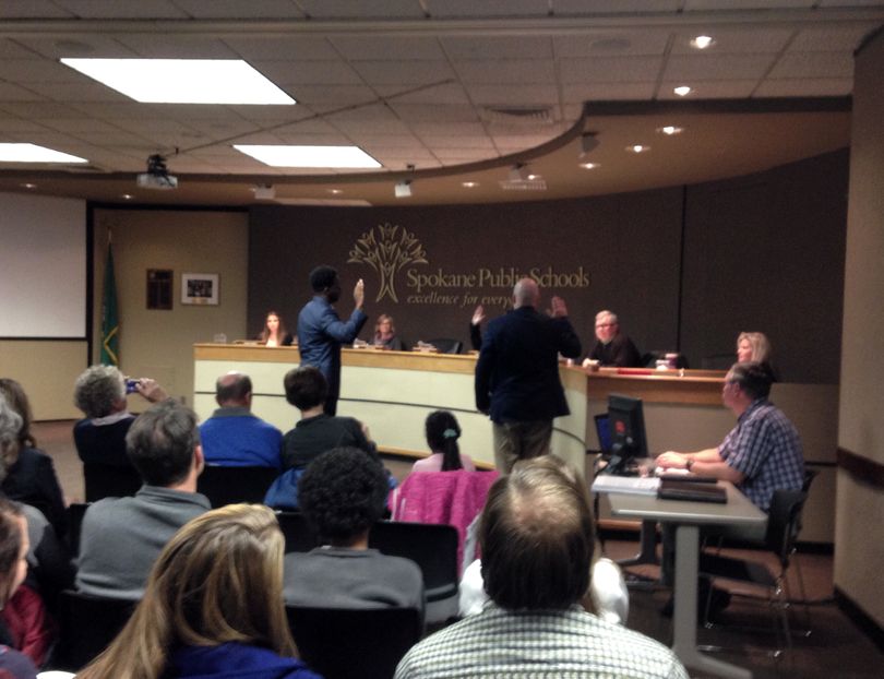 Jerrall Haynes, left, and Paul Schneider are sworn in as Spokane Public Schools board members on Wednesday, Dec. 2.