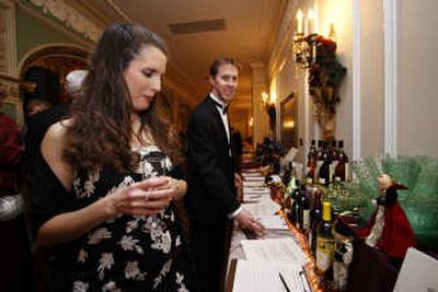 
Deanna Kriegh, left, and Keith Kriegh review silent auction items at Diamonds and Divas, a New Year's Eve event benefiting the Spokane Opera. Special to 
 (Photos above by Young Kwak Special to / The Spokesman-Review)