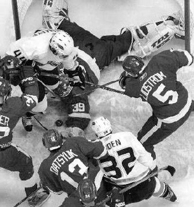 
A prone Detroit goalie Dominik Hasek (39) tries to cover the puck amidst a flurry of activity in front of the net.
 (Associated Press / The Spokesman-Review)