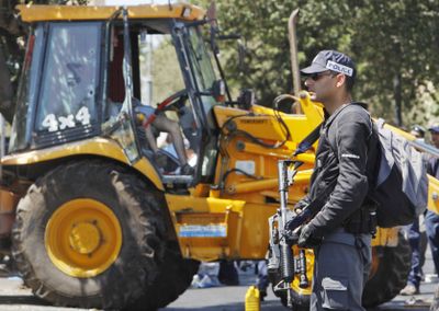 An Israeli security force officer guards an earthmover after its Palestinian driver  was shot dead in Jerusalem on Tuesday. (Associated Press / The Spokesman-Review)