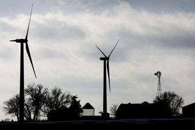 Two wind turbines stand near a traditional windmill on a farm near Mount Carmel, Iowa. A first-of-its-kind study suggests wind speeds are slowing in the Midwest.  (File Associated Press / The Spokesman-Review)
