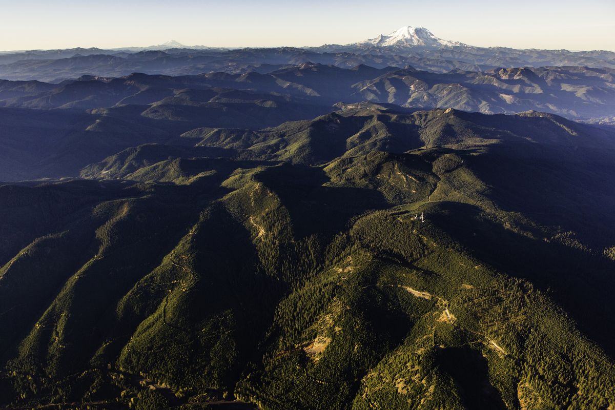 Aerial view of the Great Western Checkerboards Project south of Cabin Creek, Washington, with Mt. Rainier in background. The Great Western Checkerboards Project preserves recreational access and helps conserve the ecological integrity of 165,073 acres – 257 square miles – of forests, rivers and wildlife habitat in the Cascade Mountain Range of Washington and in the Blackfoot River Valley in Montana. This transaction with Plum Creek is one of the largest land acquisition projects undertaken by the conservancy.  (Benjamin Drummond / LightHawk)