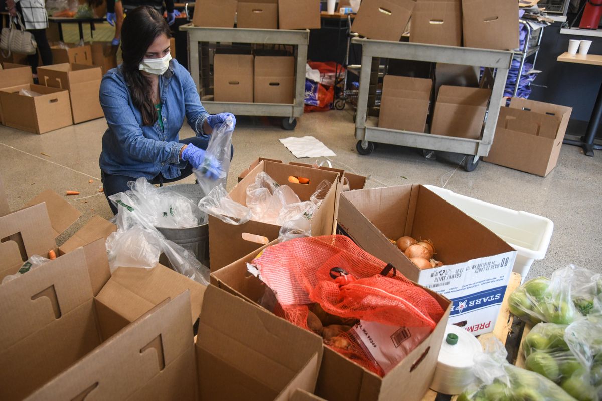 Camila Oliveira gathers radishes for some of the 350 emergency food boxes, Friday, May 15, 2020, at Eat Good Cafe in Liberty Lake, Wash. The Inland Northwest Farmers Market Association and Share.Farm have received a USDA “Farmers to Families” contract valued up $1.4 million to provide boxes of fresh produce, dairy and meat products to those in need during COVID-19 pandemic. (Dan Pelle / The Spokesman-Review)