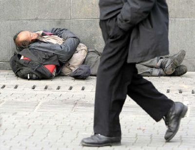 
A homeless man sleeps on a street in Shanghai. Despite a booming economy, China is still home to enormous sectors of poverty.
 (Associated Press photos / The Spokesman-Review)