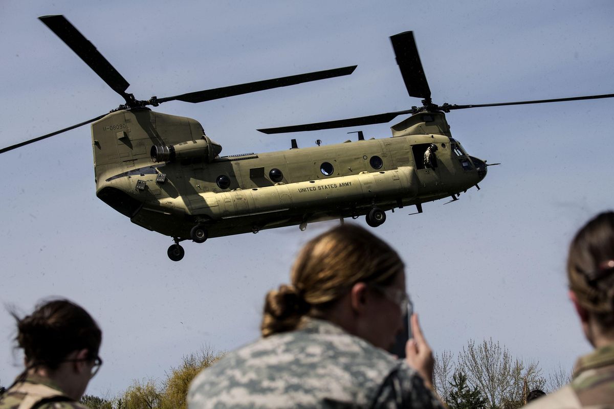 ROTC  cadets watch the landing of a Chinook helicopter on Luger Field at Gonzaga University on Sunday, April 22, 2018. Marking the 70th anniversary of the Gonzaga ROTC this year, a Boeing CH-47 Chinook helicopter was used to will fly cadets to Camp 7 Mile for their Spring Field Training Exercise. (Kathy Plonka / The Spokesman-Review)