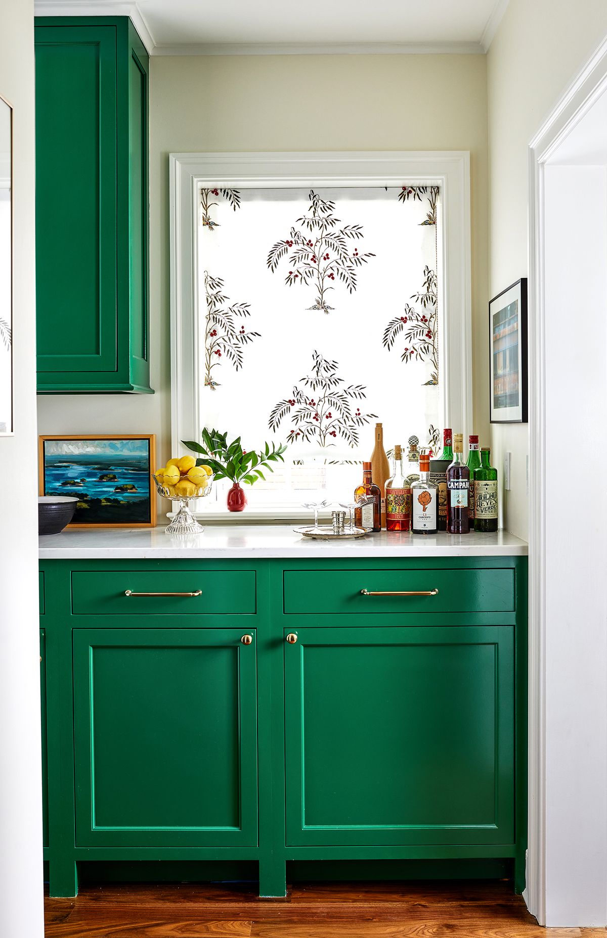 A tiny red vase accents the green butler’s pantry in this space designed by Annie Elliott.  (Courtesy of Stacy Zarin Goldberg)