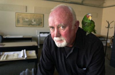 
Terry Hughes of Blue Line Home Design, shown with his Amazon parrot, Clancy, works from his office on the corner of Cedar Street and First Avenue in downtown Spokane. The company is selling stock home plans over the Internet. 
 (Dan Pelle / The Spokesman-Review)