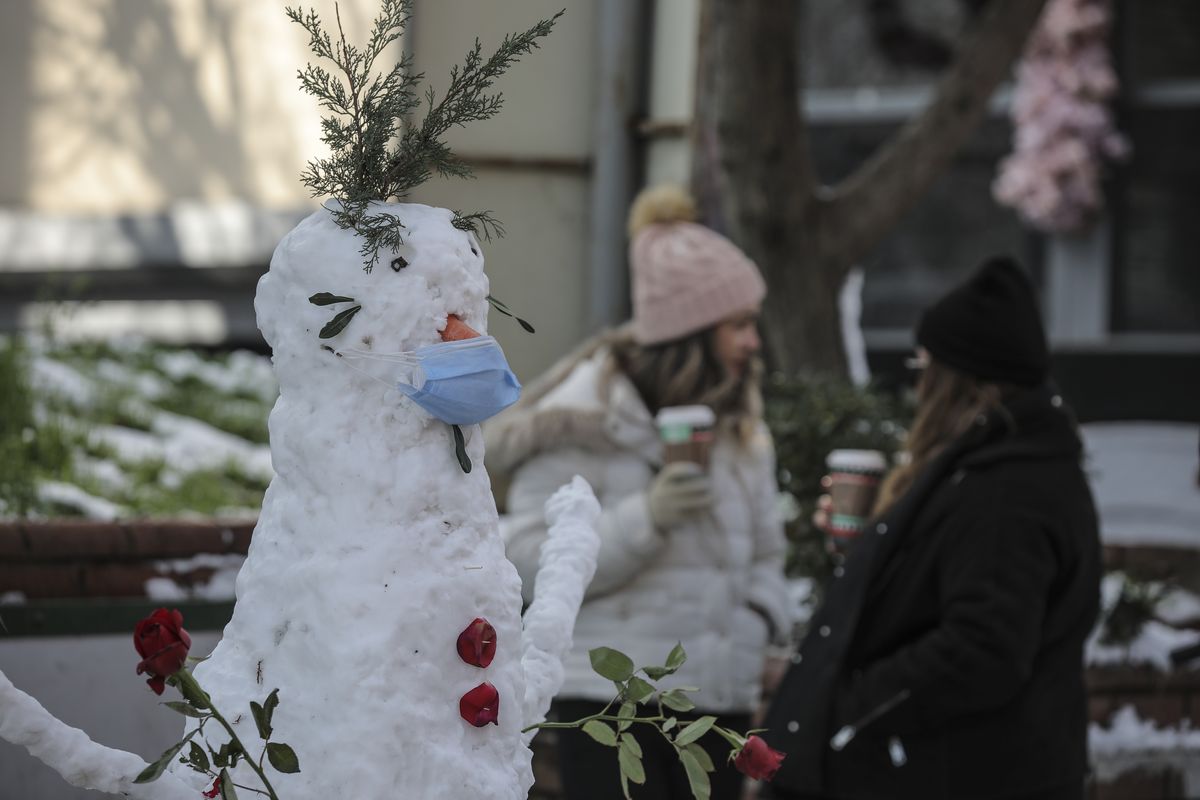 A snowman, featuring a mask, is seen in Istanbul, Monday, Jan 18, 2021. Snow blanketed most of the Turkish metropolis of some 16 million that spans two continents, bridging Europe to Asia and the flurries are forecasted to continue throughout the day.  (Emrah Gurel)
