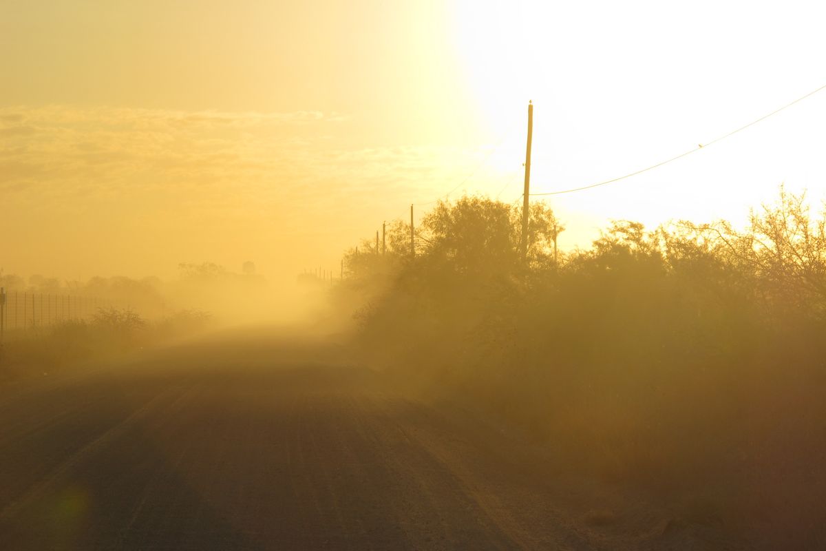 The sun rises along the stretch of gravel road near La Joya, Texas, Friday Oct. 26, 2012, where a Texas Department of Public Safety helicopter and sharpshooter assisted the previous day in the chase of a suspected illegal immigrant smuggler. Two people in the fleeing vehicle were killed and a third was wounded. (Chris Sherman / Associated Press)