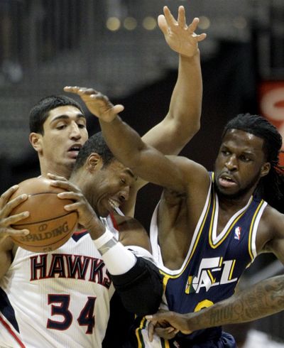 Atlanta Hawks' Jason Collins, front, defends the ball as he fights past the Utah Jazz's Enes Kanter, rear, and DeMarre Carroll. (Associated Press)