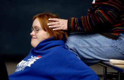 
Felicia Edwards, 18, of Coeur d'Alene leans on Lisa Pangle, a Specialized Needs Recreation staff member during the opening remarks on the first day of the weeklong Camp Allstars 
