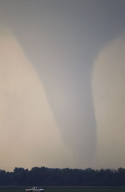 A truck drives along Interstate 70 as a tornado moves on the ground north of Solomon, Kan., on Saturday. (Associated Press)