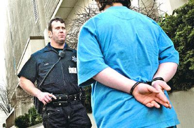 
Off-duty sheriff's Deputy Tim Jones detains a juvenile accused of smoking and lying about his age on Tuesday. Washington Trust Bank has hired officers to patrol in front of its downtown building amid complaints about loitering teenagers.
 (Colin Mulvany / The Spokesman-Review)